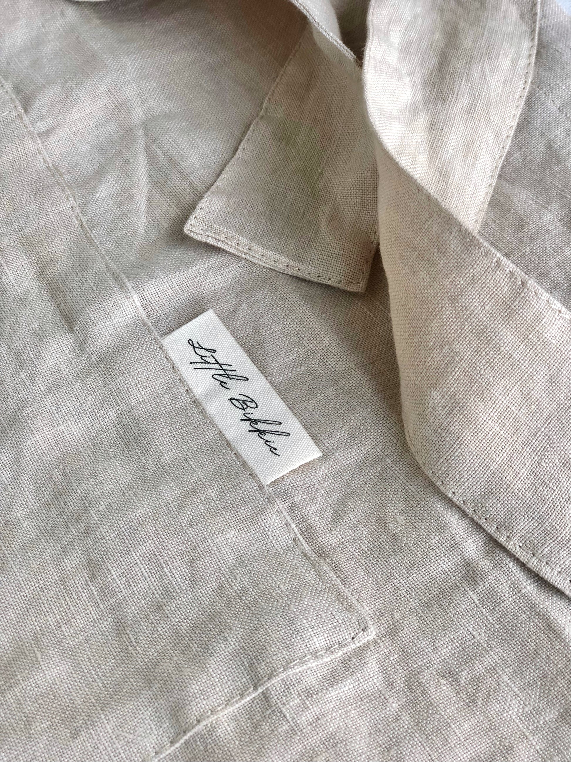 100% linen half waist apron. Large front pocket. Long ties can be fastened at the back or at the front, creating a large bow. Beige colour way.