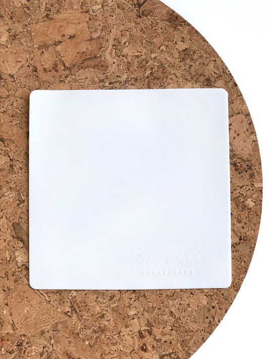 Small, white silicone mat for use with cookie turntable. 